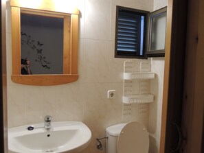 A bathroom with a sink, toilet, and a mirror with a wooden frame. - Apartment for 2–3 people with a garden, parking, air conditioning, and Wi-Fi. C/DISCOUNTS FOR JULY–SEPTEMBER (San Fernando)