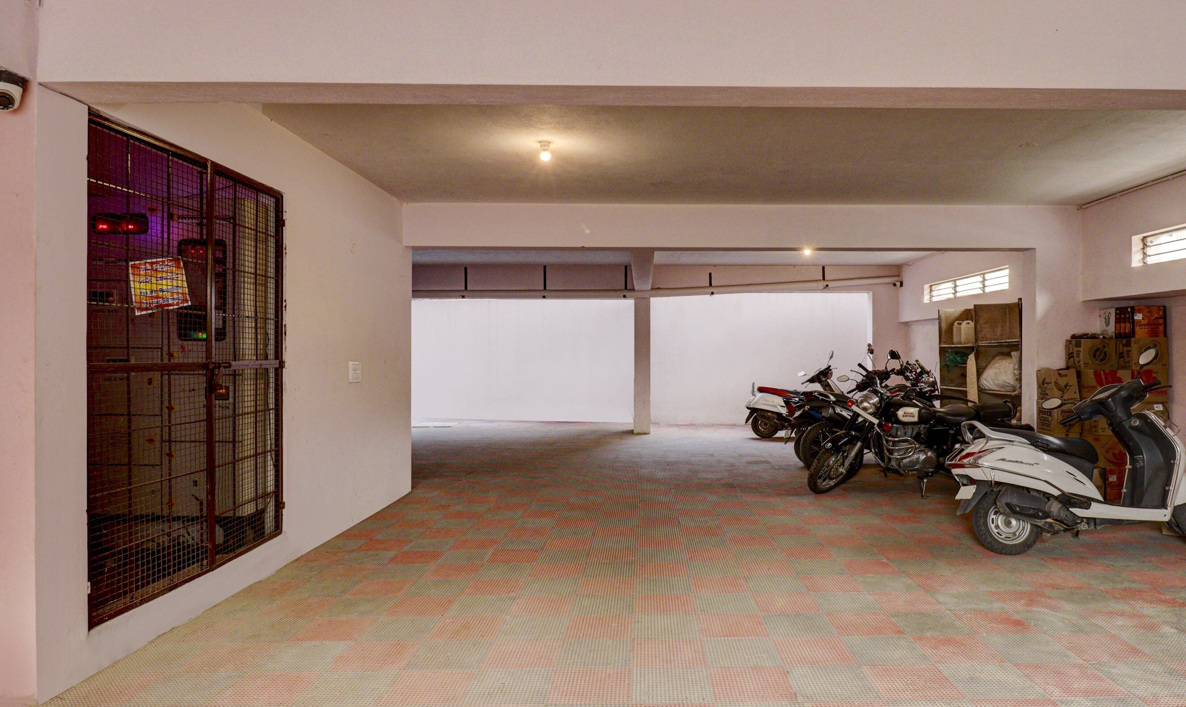 A parking garage with several motorcycles and scooters parked.