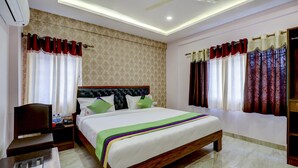 A hotel room with a bed, nightstand, and a telephone. - Treebo Three Street Inn (Bengaluru)