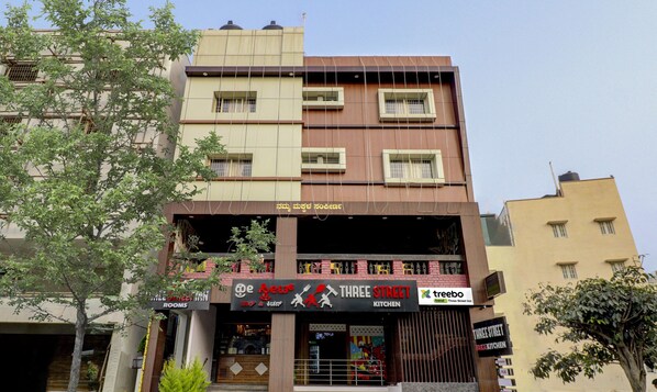 Un edificio de varios pisos con un restaurante llamado "Three Street Kitchen" en la planta baja.