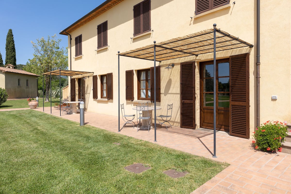 A building with a patio area, outdoor seating, and a covered walkway.