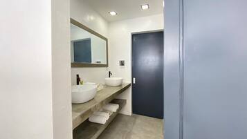 A bathroom with two sinks, a mirror, and a door.