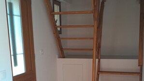 A room with a wooden ladder, a door, and a tiled floor. - Quiet semi-detached house with swimming pool (Grasse)