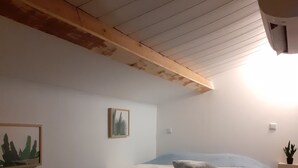 A bedroom with a bed, a nightstand, a wall-mounted light, and a framed picture. - Quiet semi-detached house with swimming pool (Grasse)