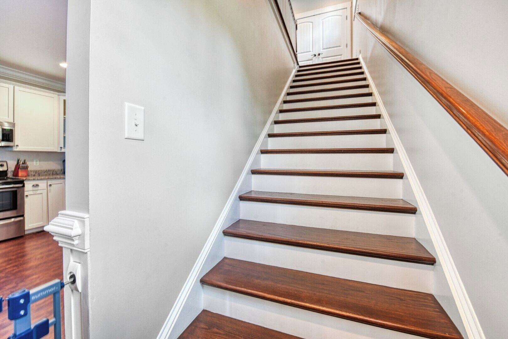 A staircase with wooden steps and white walls.