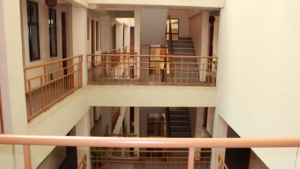 A multi-level interior with a staircase connecting floors, metal railings, and a view of the lower level. - Roof Galaxy Hotel (Machakos)