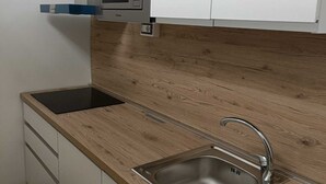 A compact kitchen with a microwave, sink, and wooden countertop. - Mirosa mini loft for you. (Bari)