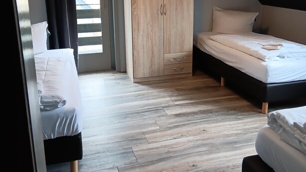 Een slaapkamer met een bed, een kledingkast en een bureau.