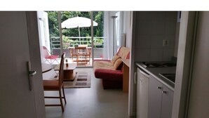 A kitchen with a dining area, a sofa, and a table with chairs. - Sudio + terrace 8m² center, beaches, south & parking (Anglet)