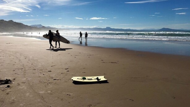 A beach with people walking and carrying surfboards. - Sudio + terrace 8m² center, beaches, south & parking (Anglet)