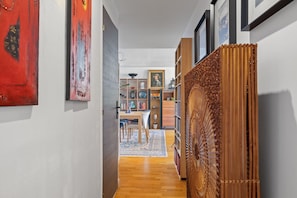 Un couloir doté d’un plancher en bois, d’un tapis à motifs et d’une structure décorative en fibres tressées.