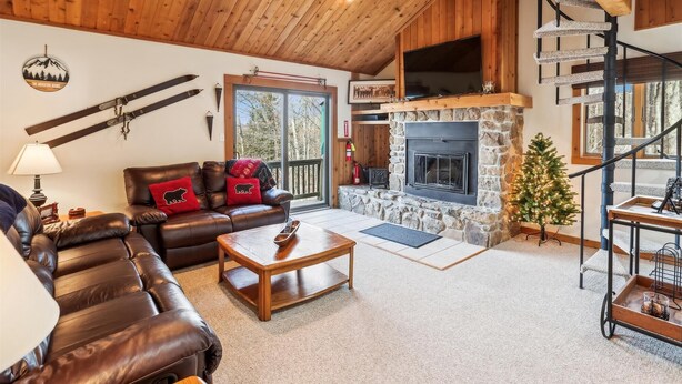 A cozy living room with a fireplace, leather sofa, and a stone fireplace surround. - Ready to ski? This is the place to be! Check out Ski Ride Inn!! (Canaan Valley)