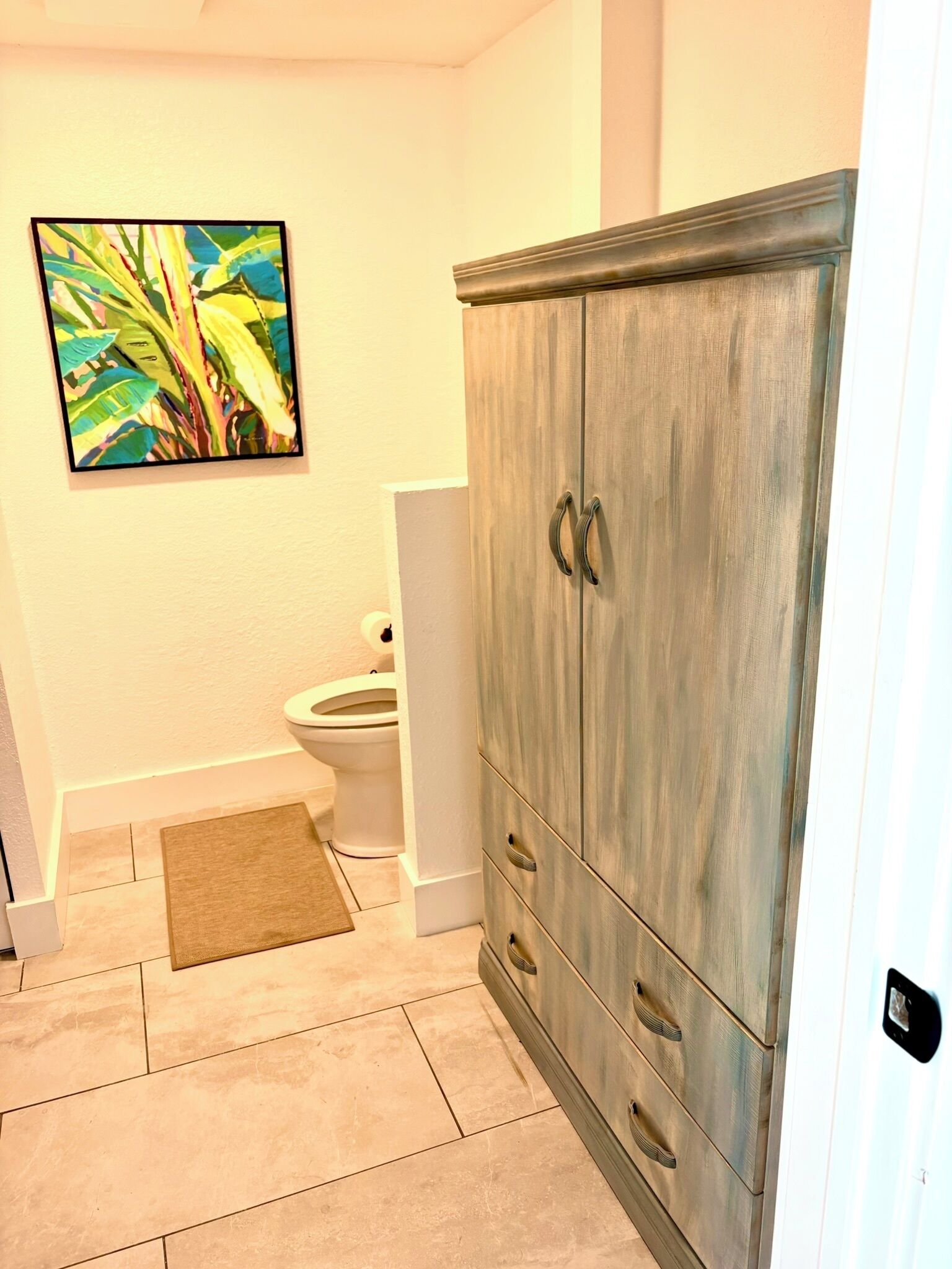 Une salle de bain avec un meuble en bois, des toilettes et un espace douche.
