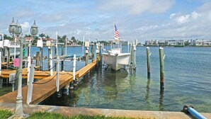Ein Yachthafen mit vertäuten Booten, ein Holzsteg und ein Fahnenmast mit einer amerikanischen Flagge.