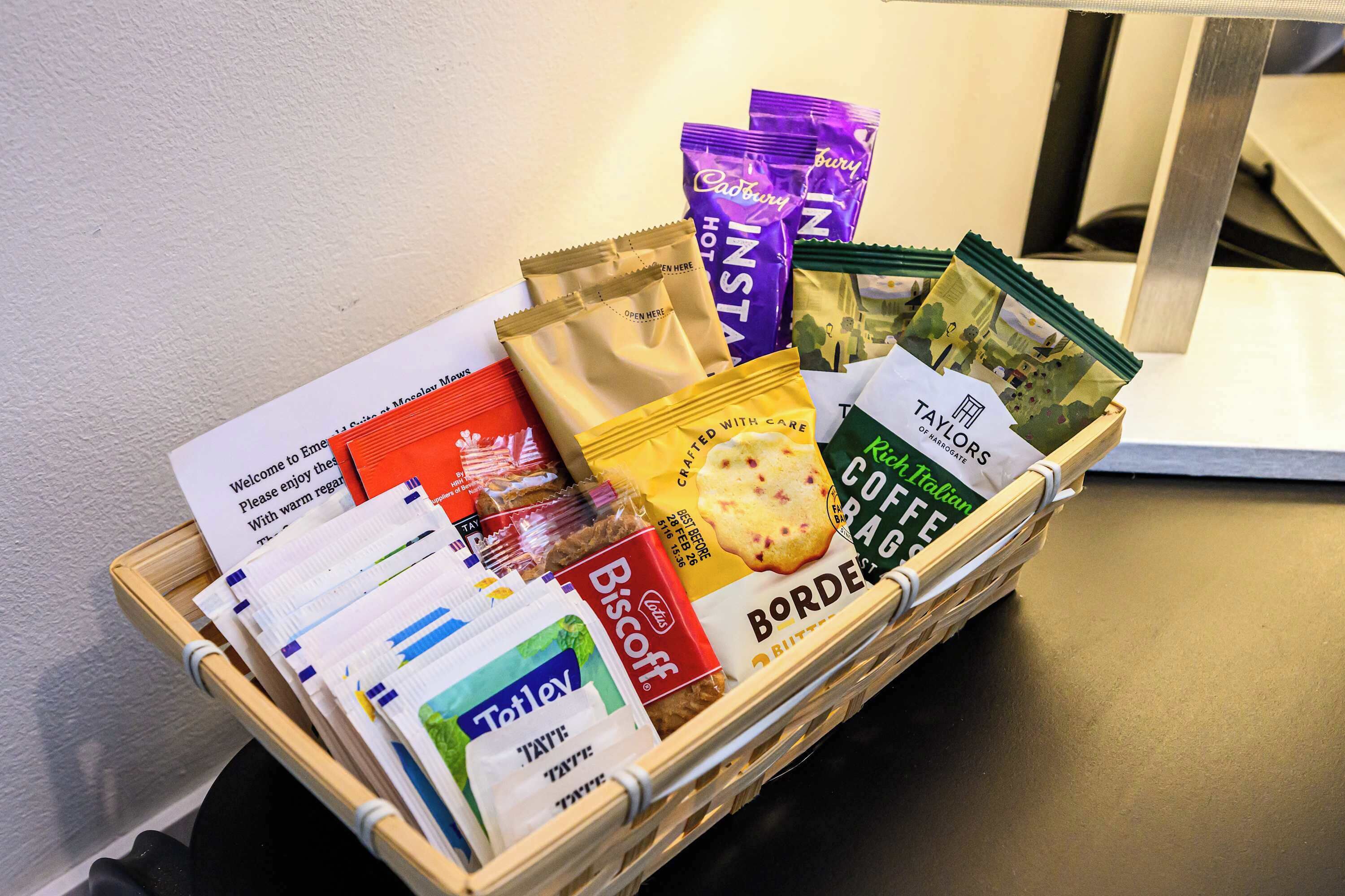 Una cesta con diferentes alimentos y una tarjeta de bienvenida.