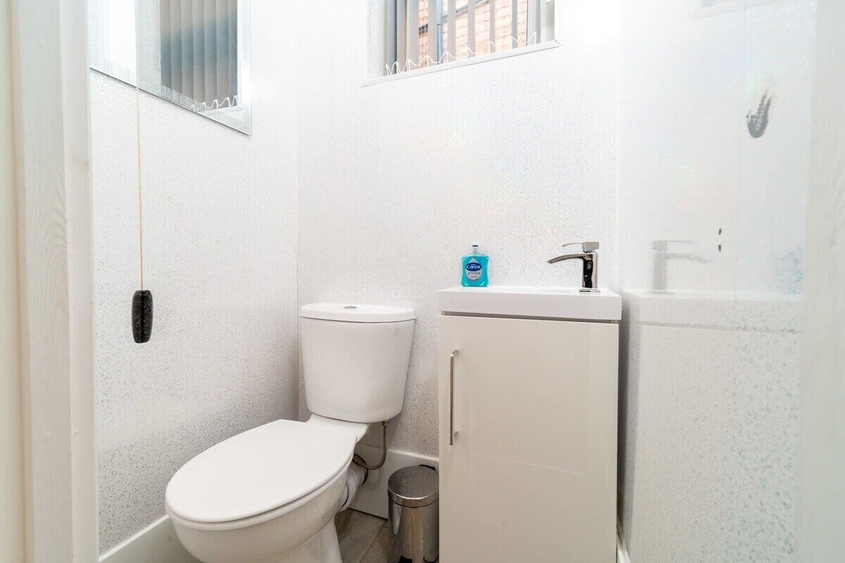 Baño pequeño y funcional con inodoro, lavabo y contenedor de basura.
