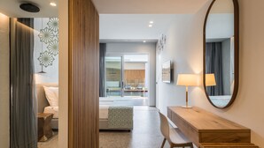 A modern hotel room with a wooden desk, a large mirror, and a bed with a geometric-patterned bedspread. - Sensus Experience by Lavris  (Hersonissos)