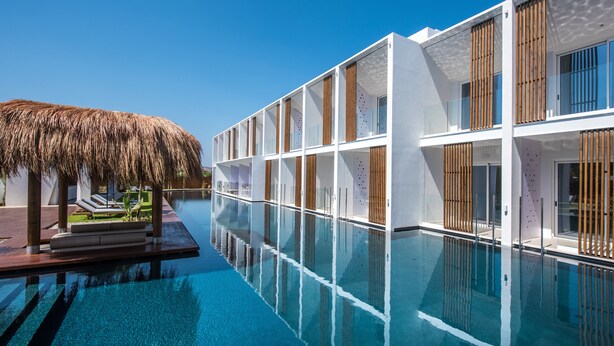 A modern hotel with a pool, wooden slatted windows, and a thatched roof structure. - Sensus Experience by Lavris  (Hersonissos)