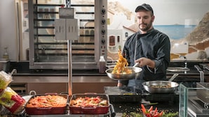 A chef preparing food in a kitchen with a view of a coastal landscape. - Sensus Experience by Lavris  (Hersonissos)