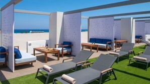 A rooftop lounge area with seating arrangements, including lounge chairs and sofas, and a view of the ocean. - Sensus Experience by Lavris  (Hersonissos)