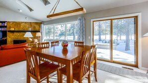 A dining area with a wooden table and chairs, a sofa, and a bookshelf. - REDC23 - Spacious Home, Gas Fireplace, Ping Pong (Sunriver)