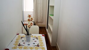 Un corridoio stretto con un tavolo ricoperto da una tovaglia decorata e un vaso con fiori.