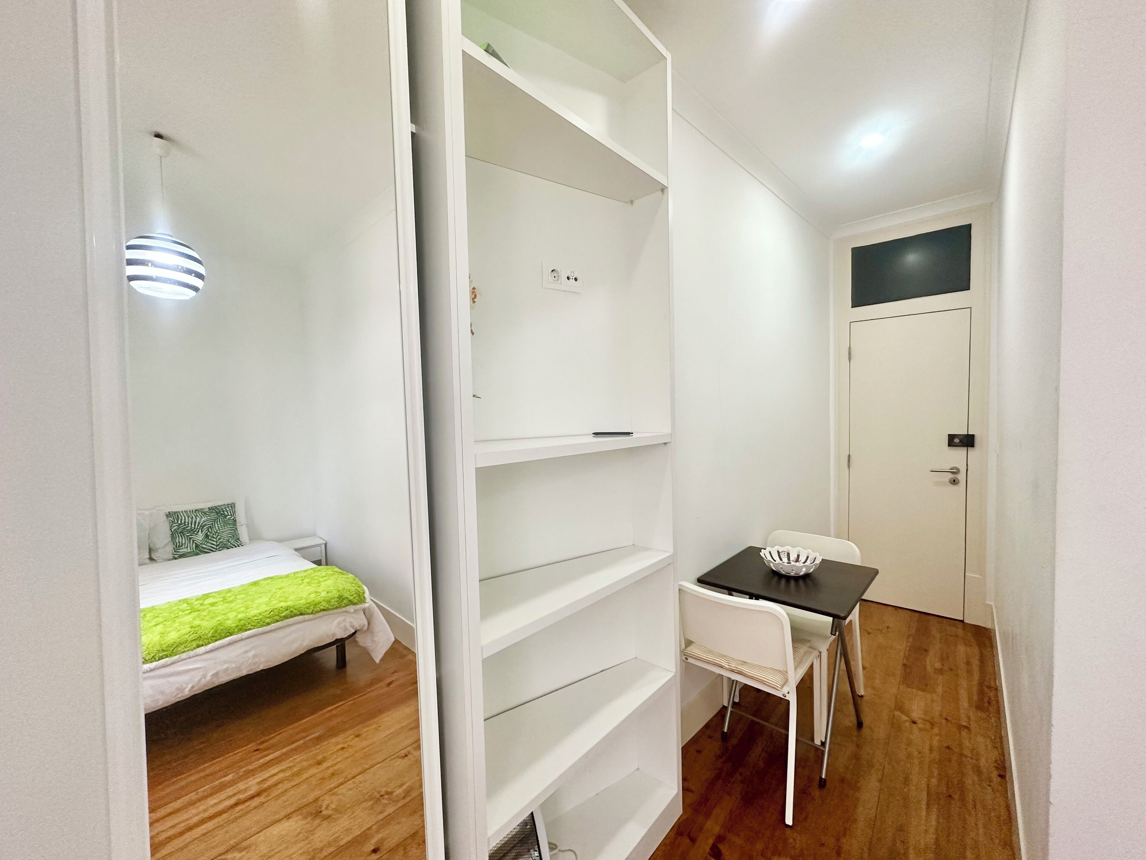Une petite chambre comprenant un lit, un bureau et une armoire.