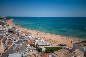 Eine Küstenstadt mit Strand, Gebäuden und blauem Himmel.
