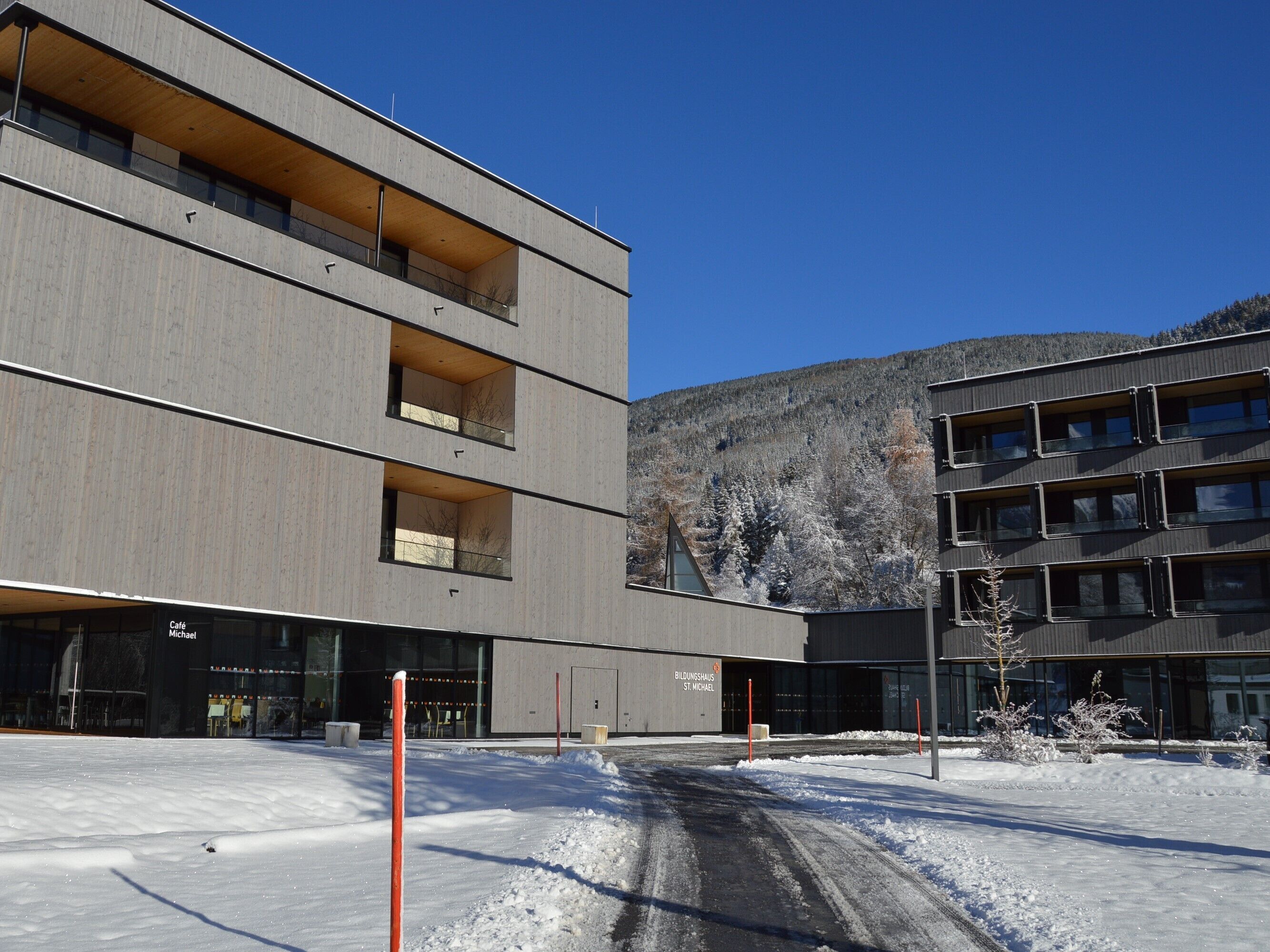 A modern building with multiple floors, large windows, and a flat roof.