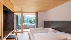 Een moderne hotelkamer met een groot bed, een bureau en uitzicht op de omgeving.