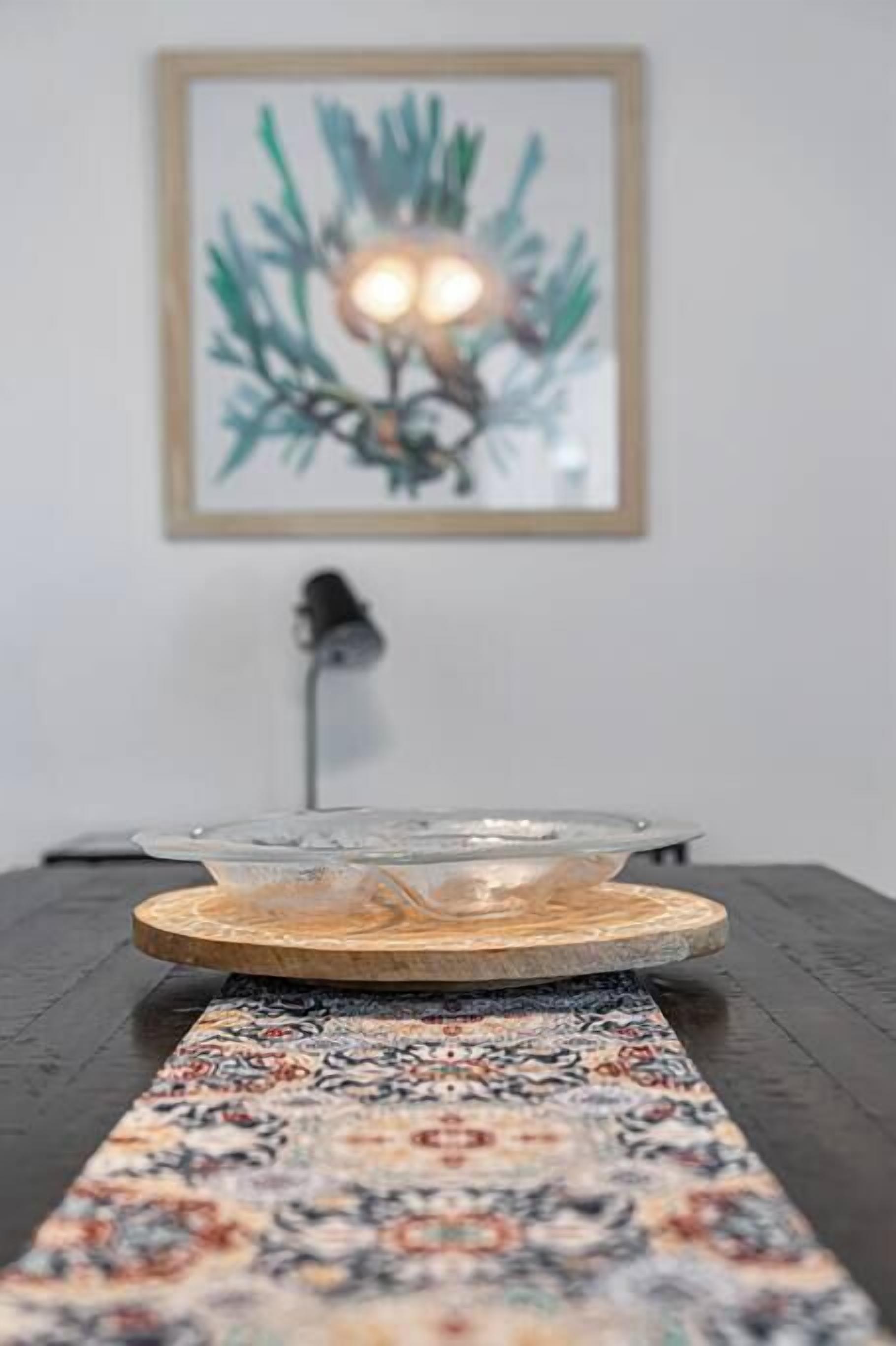 A table with a decorative tray and a patterned runner.