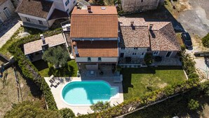 A large house with a swimming pool, surrounded by a well-maintained lawn and a stone wall. - Romantic vacation apartment with large pool and beautiful garden (Bale)