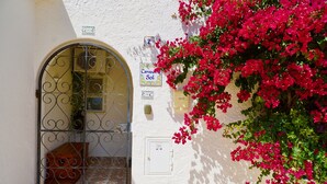 A white building with a metal gate, a utility box, and a sign with the number 2. - Carvoeiro Sol Right by the sea (Carvoeiro)
