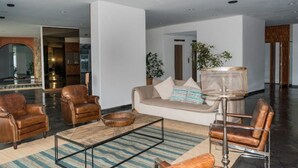 Ein modernes Wohnzimmer mit Ledersofas, einem Couchtisch und einer Stehlampe.