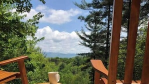 Une terrasse en bois avec un tronc d’arbre rustique et une chaise en bois.