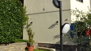 A building with a beige exterior, a black lamp post, and a potted plant. - A1-GIRASOLE BED AND BREAKFAST (Castelnuovo di Porto)