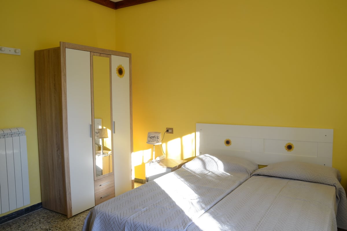 A bedroom with a bed, a wardrobe, a radiator, and a lamp.