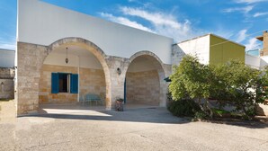 Ein Gebäude mit Innenhof, Steinbögen und einer kleinen Sitzecke.