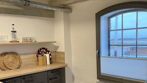 Eine moderne Küche mit Holzarbeitsplatte, einem eingebauten Herd und einem großen Fenster mit Blick auf eine schöne Landschaft.