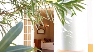 Ein Zimmer mit einem Bett, einem Nachttisch und einer Wandlampe.