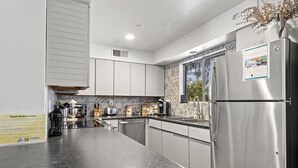 Una cucina moderna con elettrodomestici in acciaio inossidabile, un cartello con le istruzioni per il check-out e un pannello decorativo.