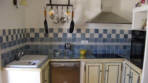 Una cocina con lavavajillas, un fregadero y una estufa.