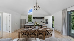 Una cucina moderna con isola centrale, mobili bianchi e un lampadario.