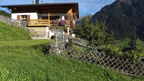 A chalet with a wooden balcony, a stone staircase, and a mountain backdrop. - Mormenta Ganda, Mormenta Ganda (Gaschurn)