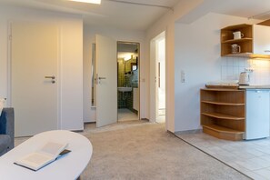 Relax in this open-plan apartment with a reading nook, kitchenette, and bathroom visible through the doorway.