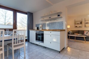 Enjoy meals at the adjacent dining area with a white table and chairs.