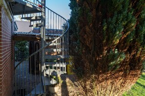 Stunning residential building with a curved staircase leading to a balcony.