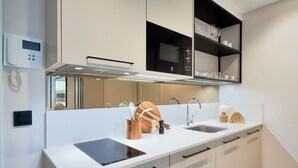 A modern kitchen with a white countertop, black cabinets, a built-in oven, and a microwave. - iloftmalaga Muelle Uno VII (Málaga)