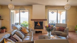 Un salón con chimenea, sofás de cuero y vistas al exterior.