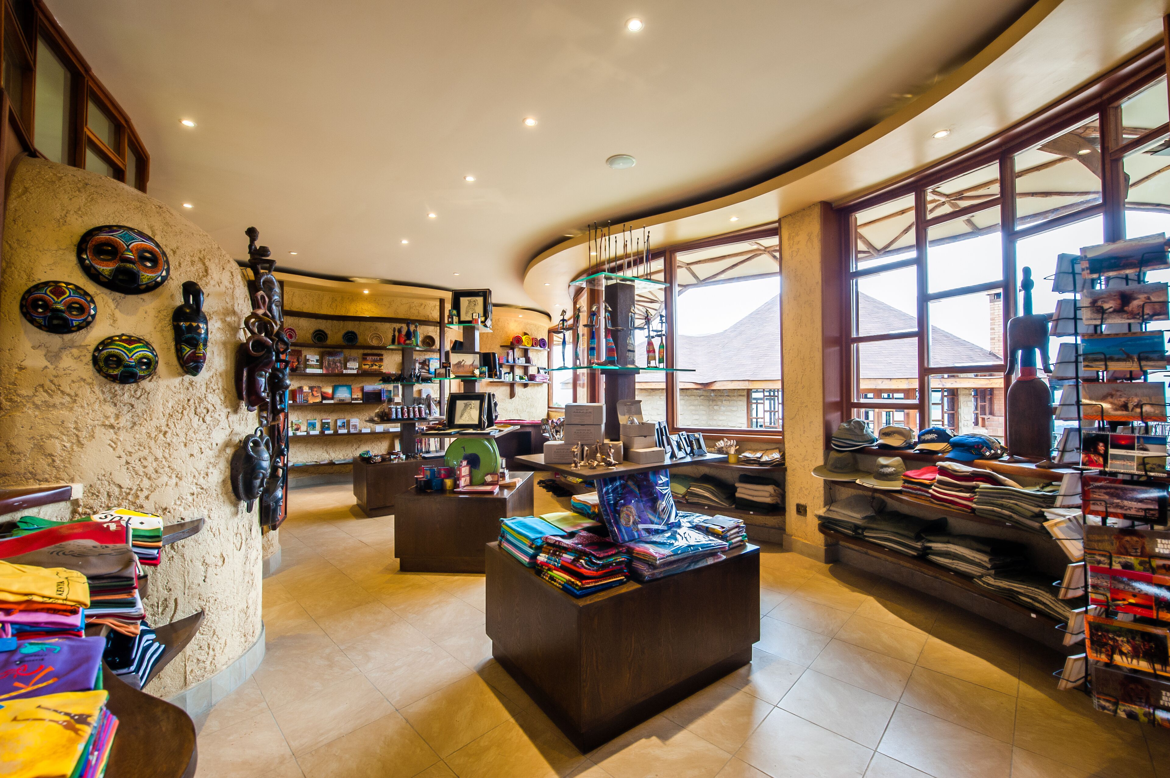 A spacious room with a curved ceiling, a large window offering a view of the mountains, and shelves filled with books and decorative items.